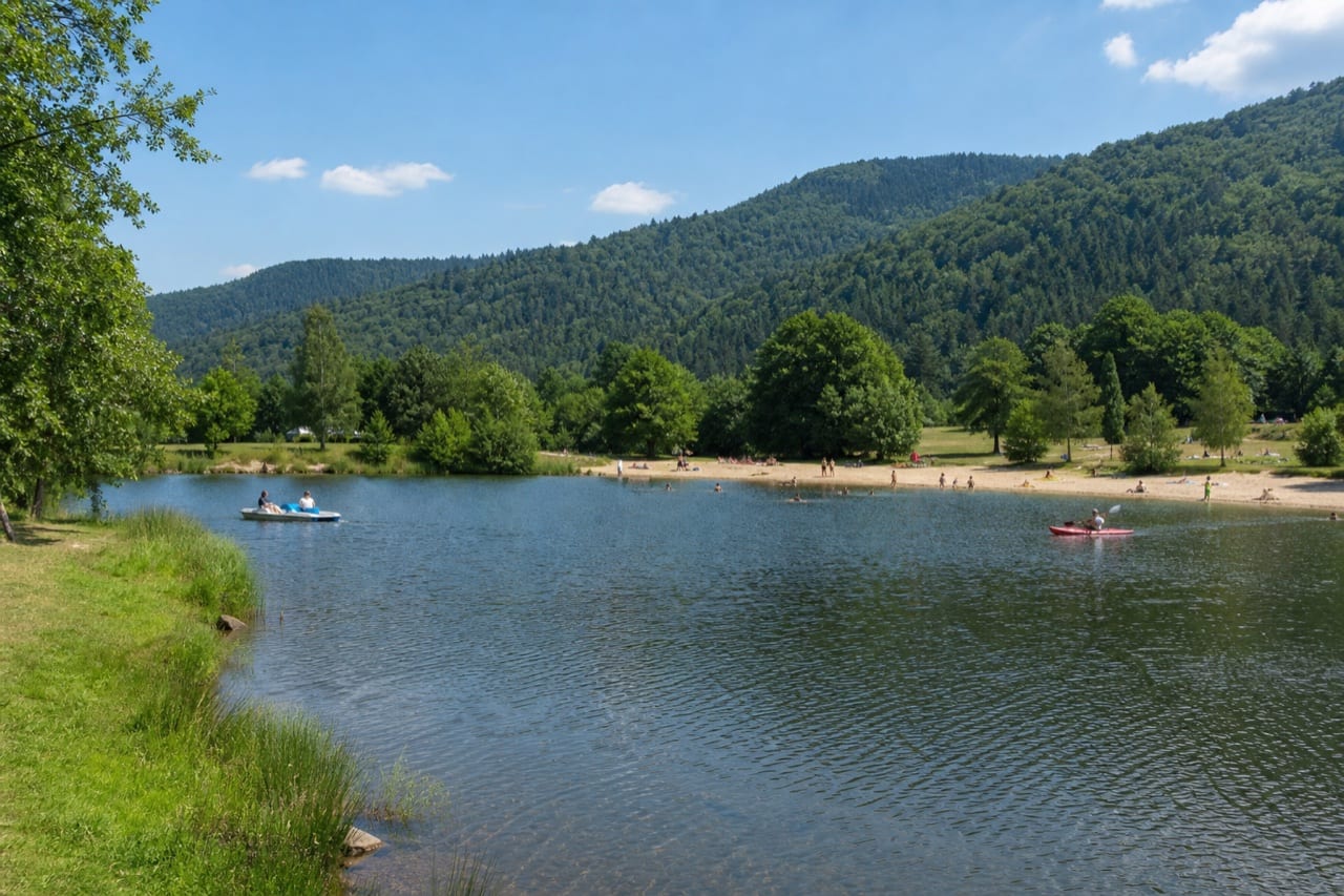 Illustration eines Freizeitsee in den Vogesen mit Strand, Tretboot und Kajak